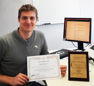 Photo taken at the award ceremony. Philippe Monmousseau is holding an award certificate.